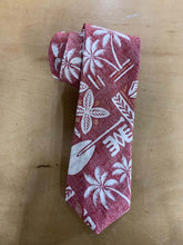 Load image into Gallery viewer, A rolled-up necktie with a red and white tropical pattern featuring palm trees, leaves, and Polynesian-inspired symbols, displayed on a light brown wooden surface.