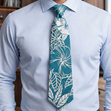 Load image into Gallery viewer, Man wearing a light blue dress shirt with a teal and white floral patterned tie.