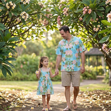 Load image into Gallery viewer, Father and daughter modeling matching Plumeria Dream tropical Hawaiian matching sets, featuring a men's Aloha shirt and a girls' Hawaiian dress handmade of 100% cotton poplin in Honolulu by kys' made in Hawaii.
