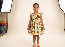 Load image into Gallery viewer, Little girl wearing the Yellow Hibiscus cotton girls hawaiian dress with flutter sleeves, handmade in Honolulu.