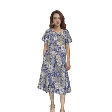 Load image into Gallery viewer, A woman wearing a blue and green floral Muumuu dress with short sleeves and a sweetheart neckline, standing against a white background.