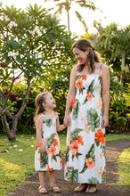 Load image into Gallery viewer, Woman and child in matching floral dresses standing in a garden.
