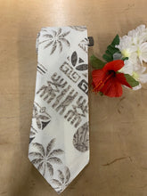 Load image into Gallery viewer, A white necktie with a black Hawaiian and Polynesian tribal pattern, laid flat on a light brown wooden surface next to artificial hibiscus flowers.
