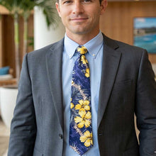 Load image into Gallery viewer, Man wearing a gray suit with a blue shirt and yellow floral tie, standing outdoors.
