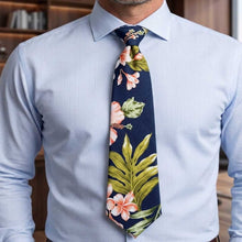 Load image into Gallery viewer, Man wearing a light blue shirt with a floral tie against a blurred indoor background
