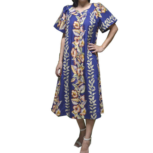 A woman wearing a plus-size Hawaiian muumuu dress in blue with a vibrant tropical floral print, featuring a sweetheart neckline and short sleeves.